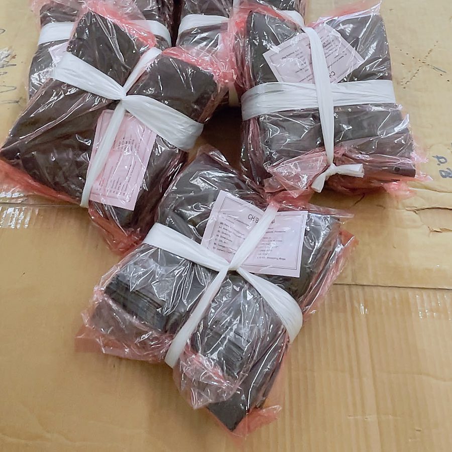 Black polythene garbage bags, bundled and labelled for despatch